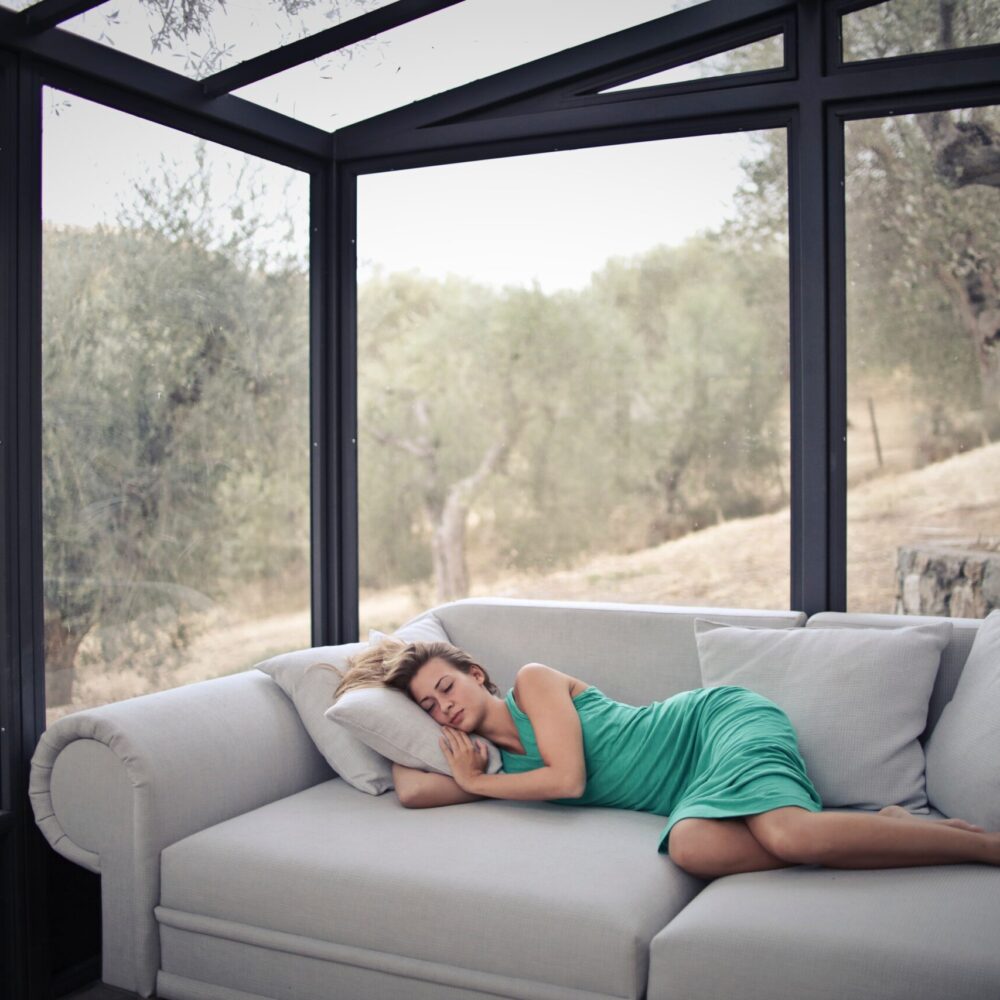 woman-sleeping-on-sofa-with-throw-pillows