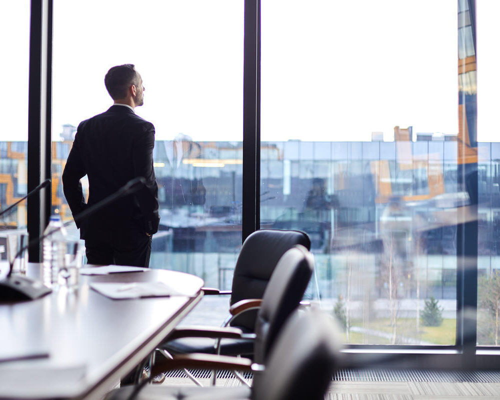 Elegant,Businessman,In,Formalwear,Looking,Through,Large,Window,In,Conference