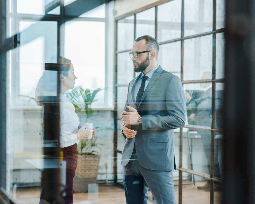 Selective,Focus,Of,Bearded,Businessman,Talking,With,Attractive,Coworker